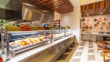 Zona de buffet con diversas frutas y verduras dispuestas en recipientes de vidrio.