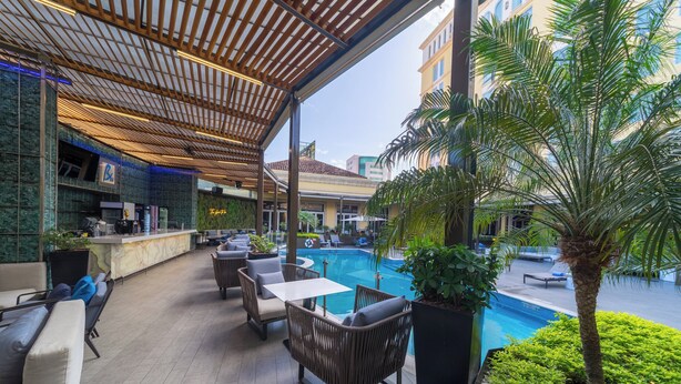 An outdoor pool area with seating and a bar.