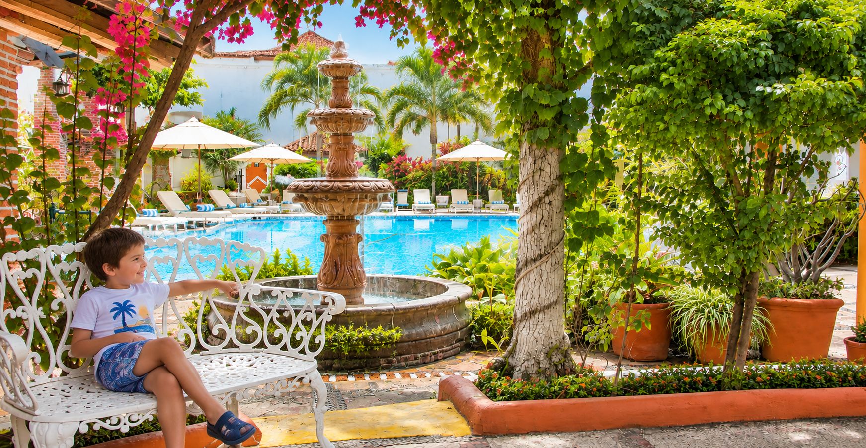 A pool area with a fountain, lounge chairs, and potted plants.