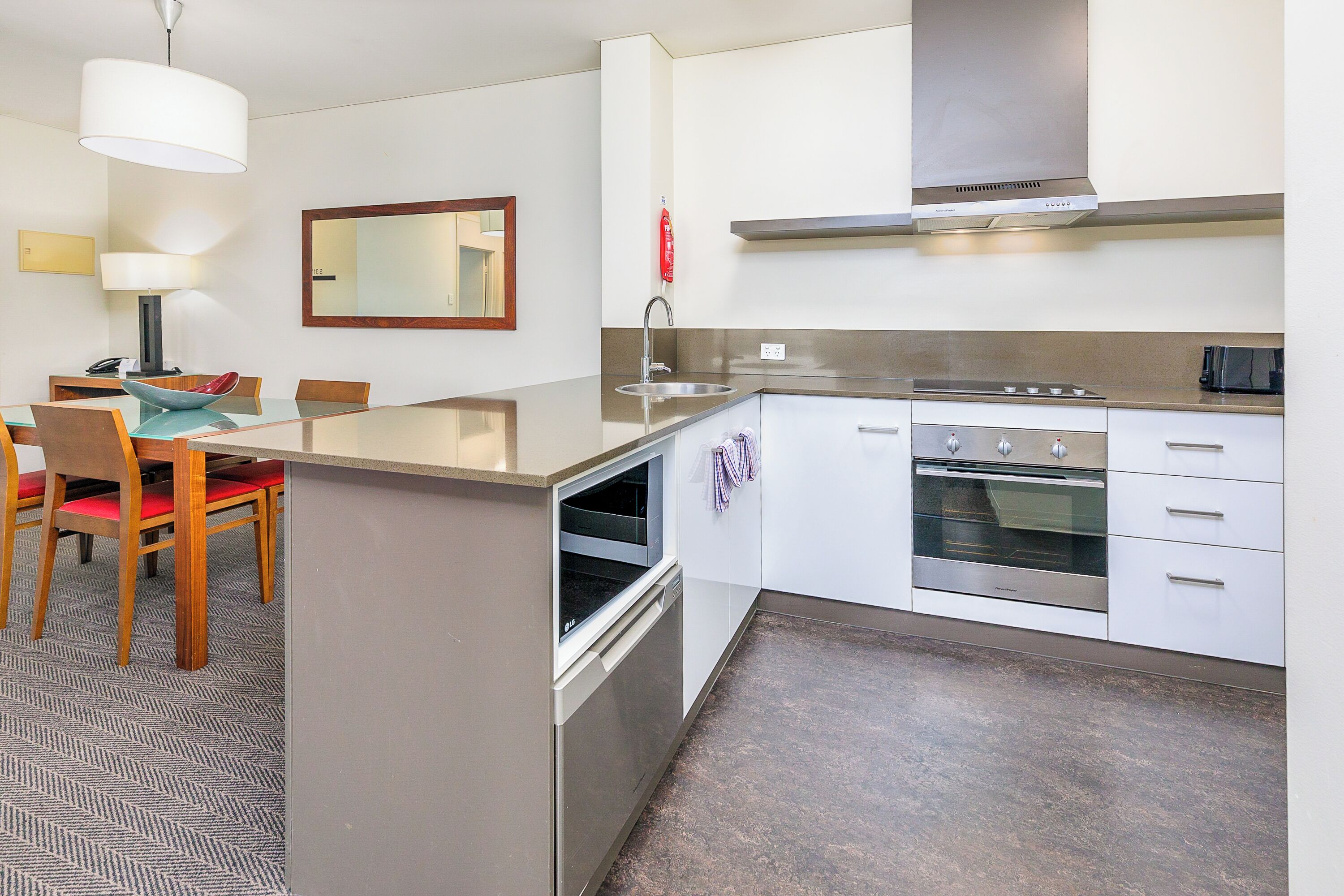 A modern kitchen with a central island, built-in oven, and stainless steel appliances.