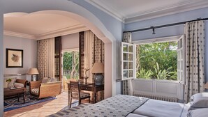 A bedroom with a large bed, a desk, a chair, and a window with a view of greenery. - Seaside Grand Hotel Residencia (San Bartolomé de Tirajana)