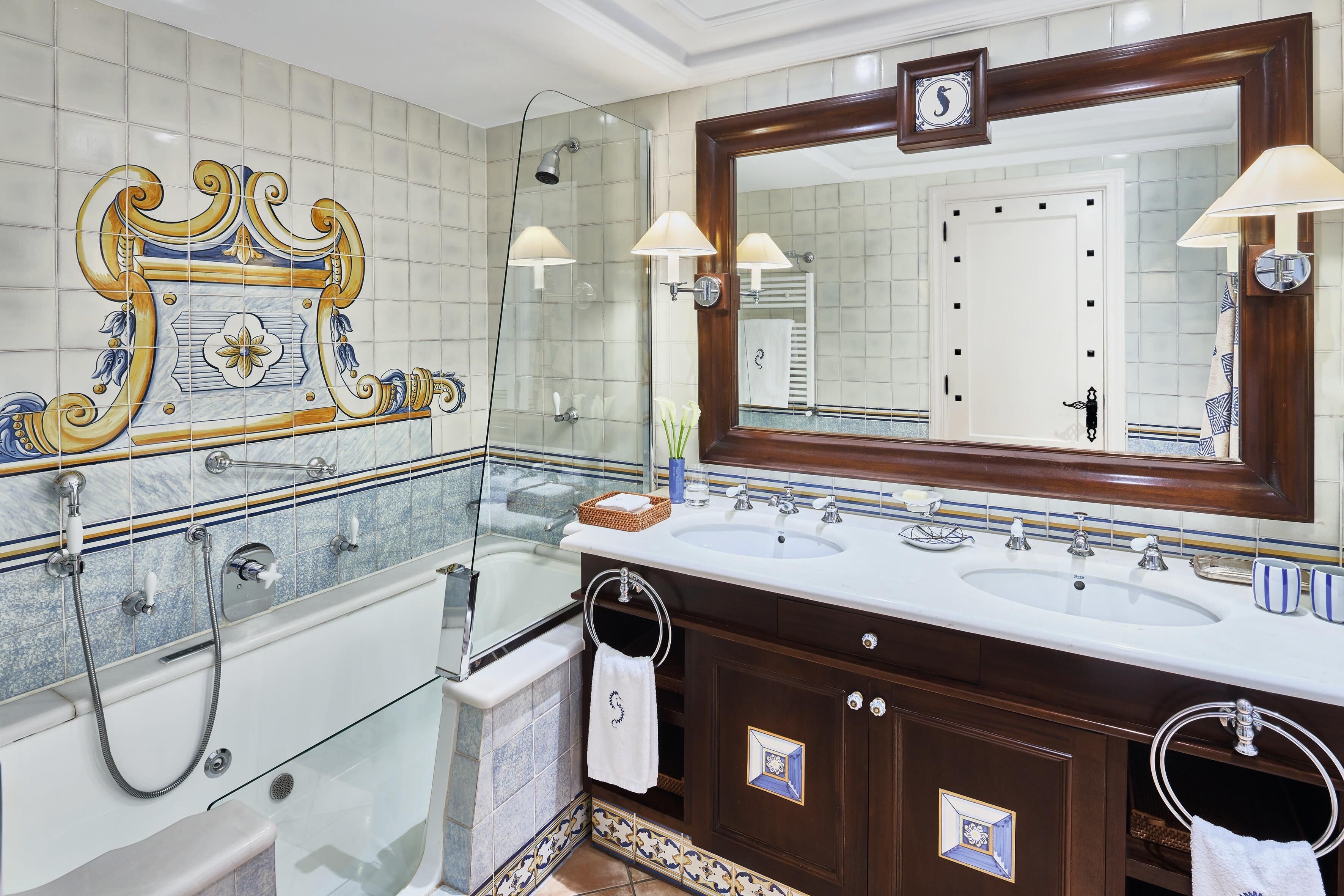 A bathroom with two sinks, a large mirror, and a shower.
