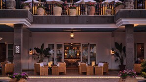 A hotel lobby with a central seating area, large potted plants, and a bar. - Seaside Grand Hotel Residencia (San Bartolomé de Tirajana)