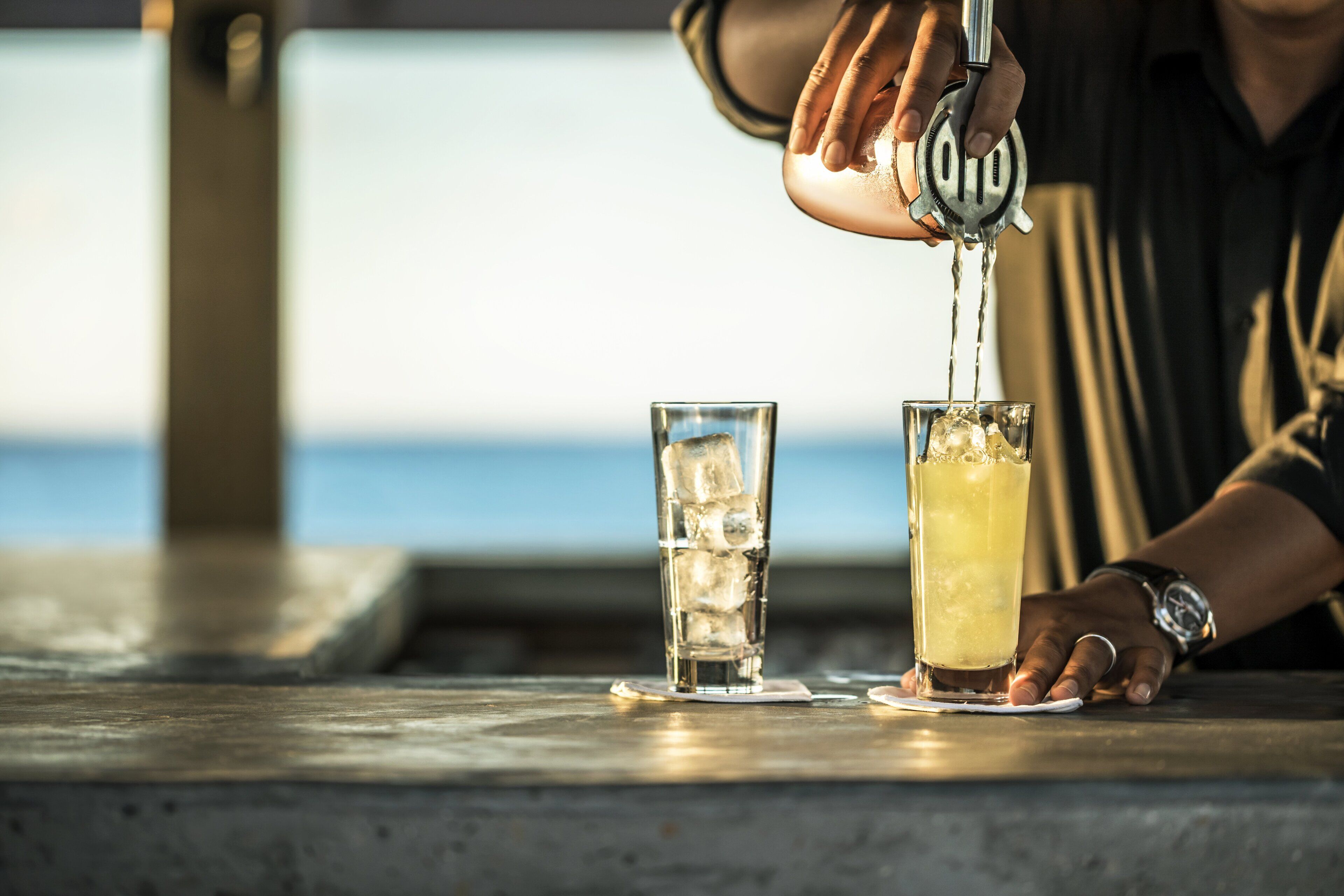 Une personne qui presse un citron dans un verre d’eau.