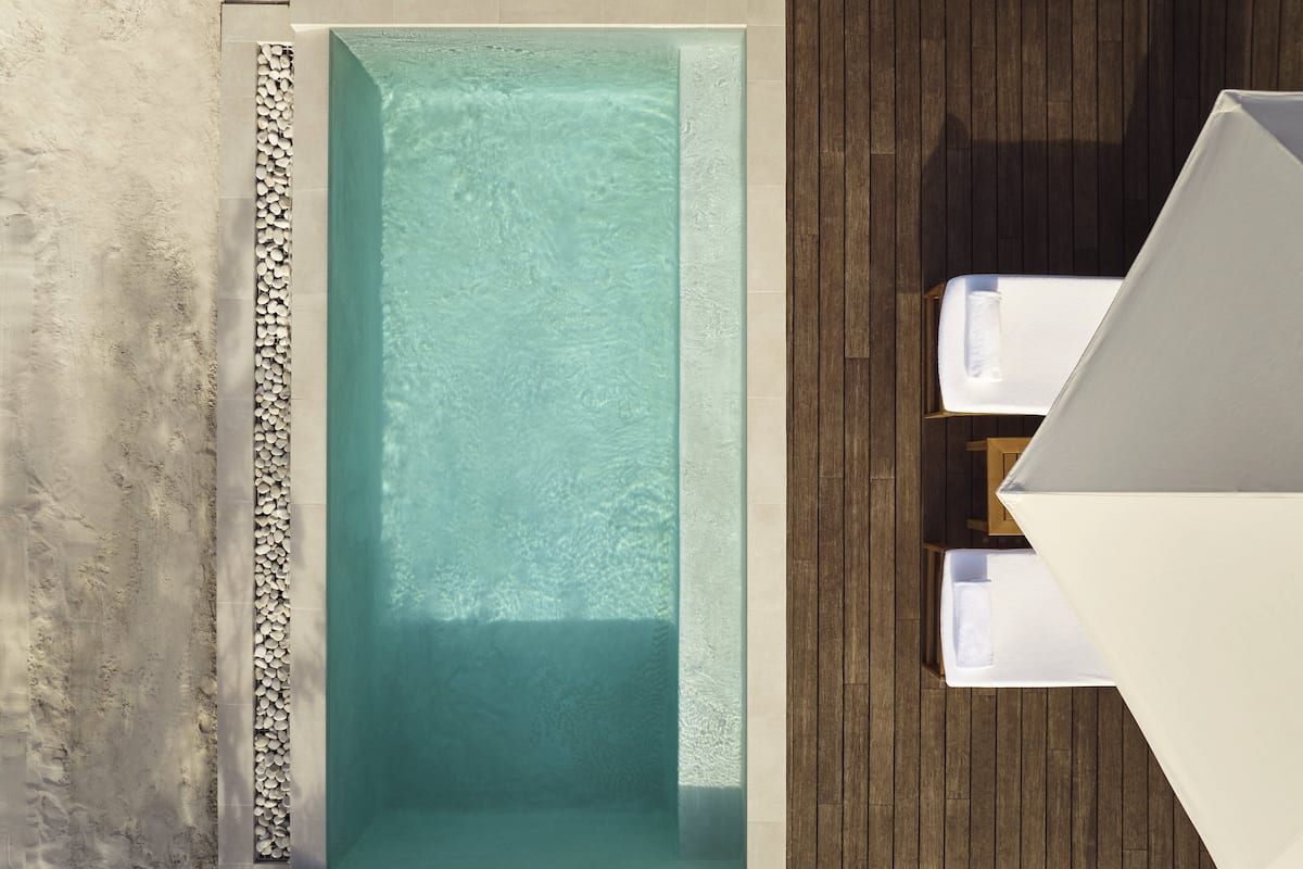 A rectangular pool with a wooden deck surrounding it.
