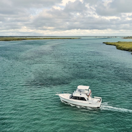 A boat on a calm river with a distant shoreline.