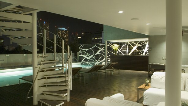 A modern rooftop lounge with a glass staircase, lounge chairs, and a pool area. - Habita, Mexico City, a Member of Design Hotels (Mexico City)