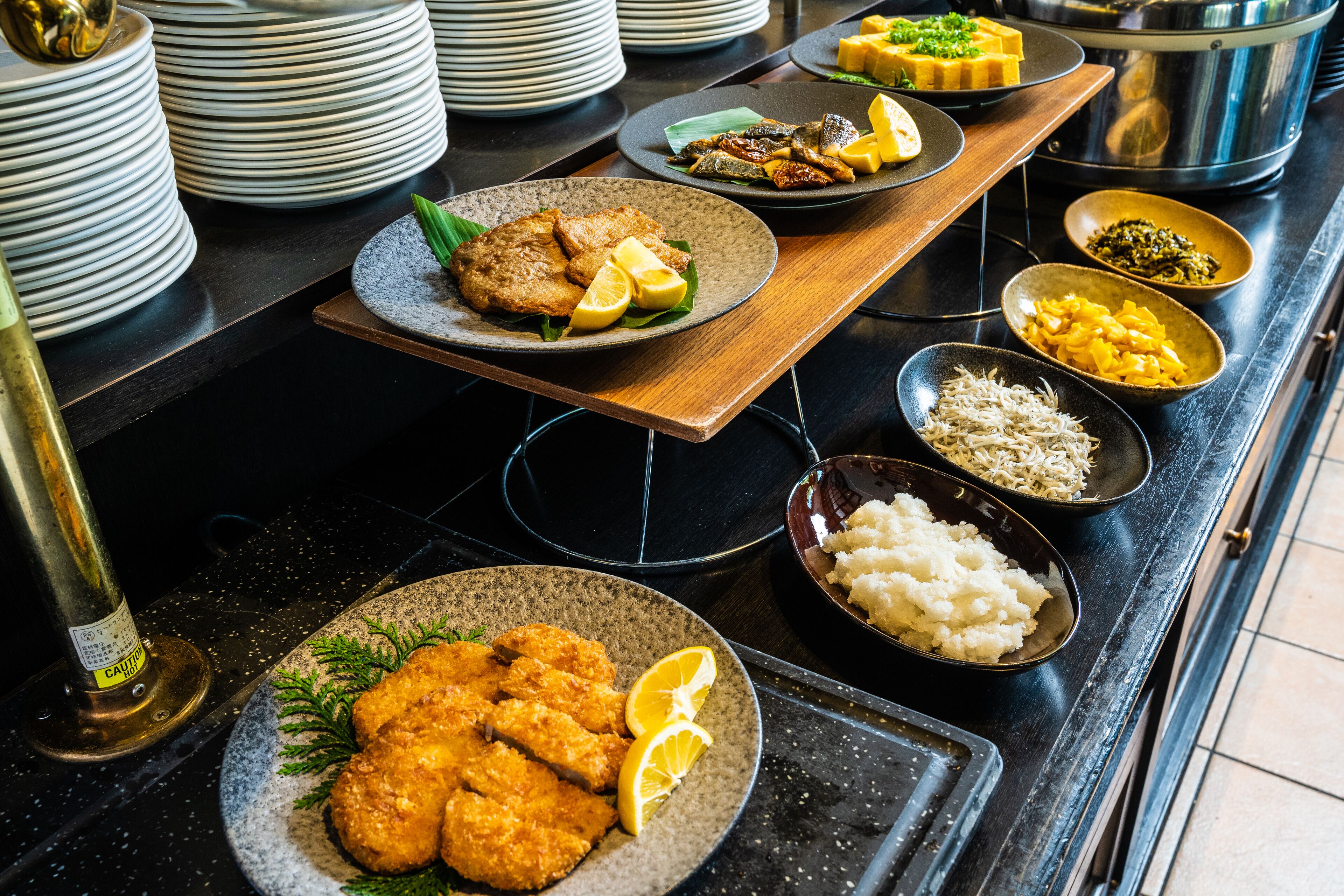A buffet table with various dishes including fried items, rice, and vegetables.