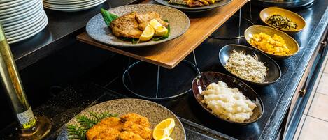 A buffet table with various dishes including fried items, rice, and vegetables.