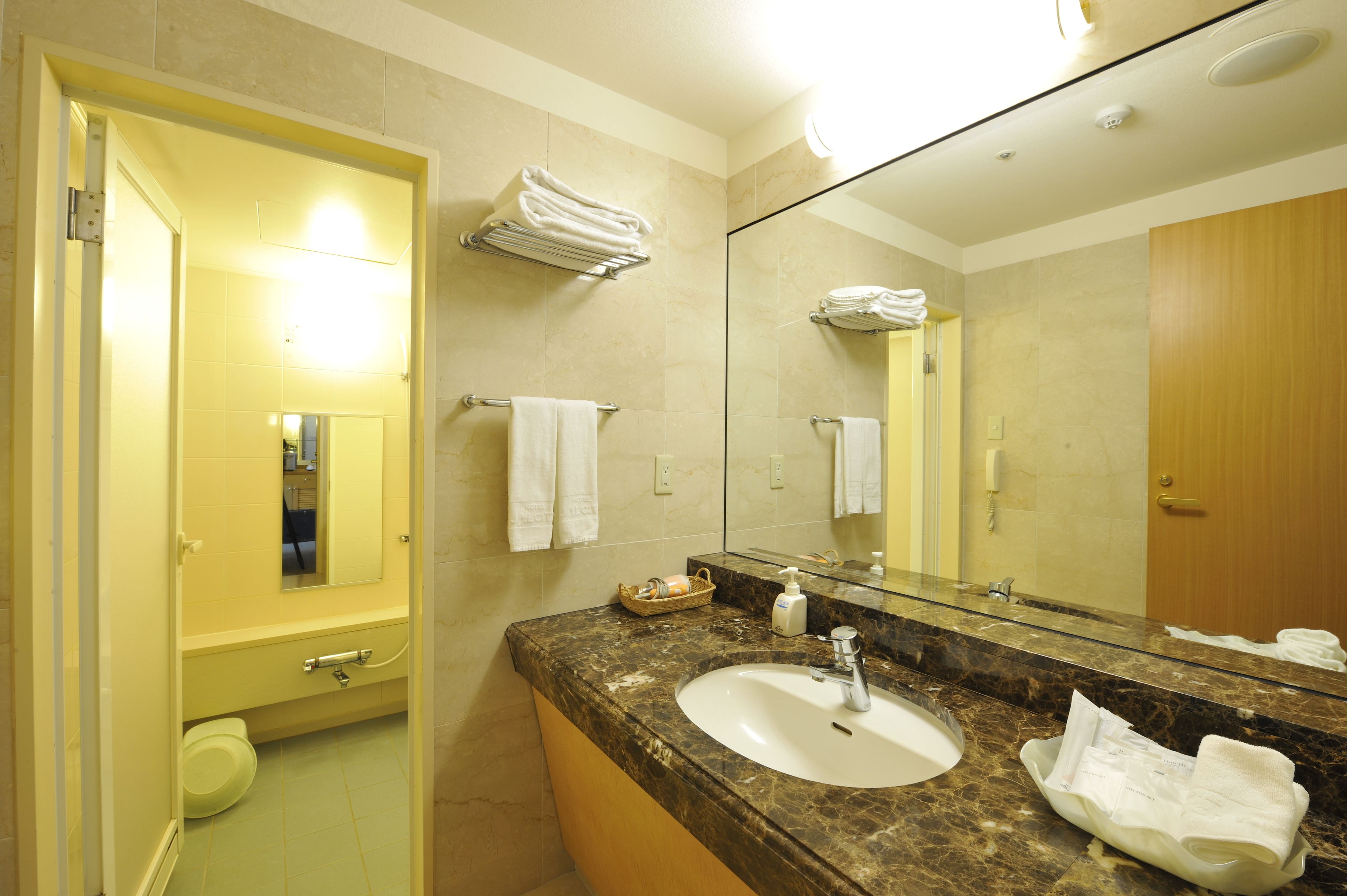 A bathroom with a sink, mirror, and towel rack.