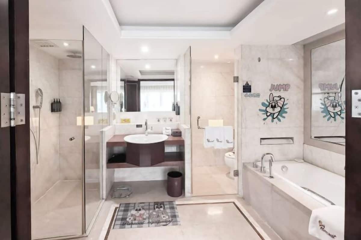 Une salle de bain moderne dotée d’une douche à parois de verre, d’une baignoire et d’un meuble-lavabo.
