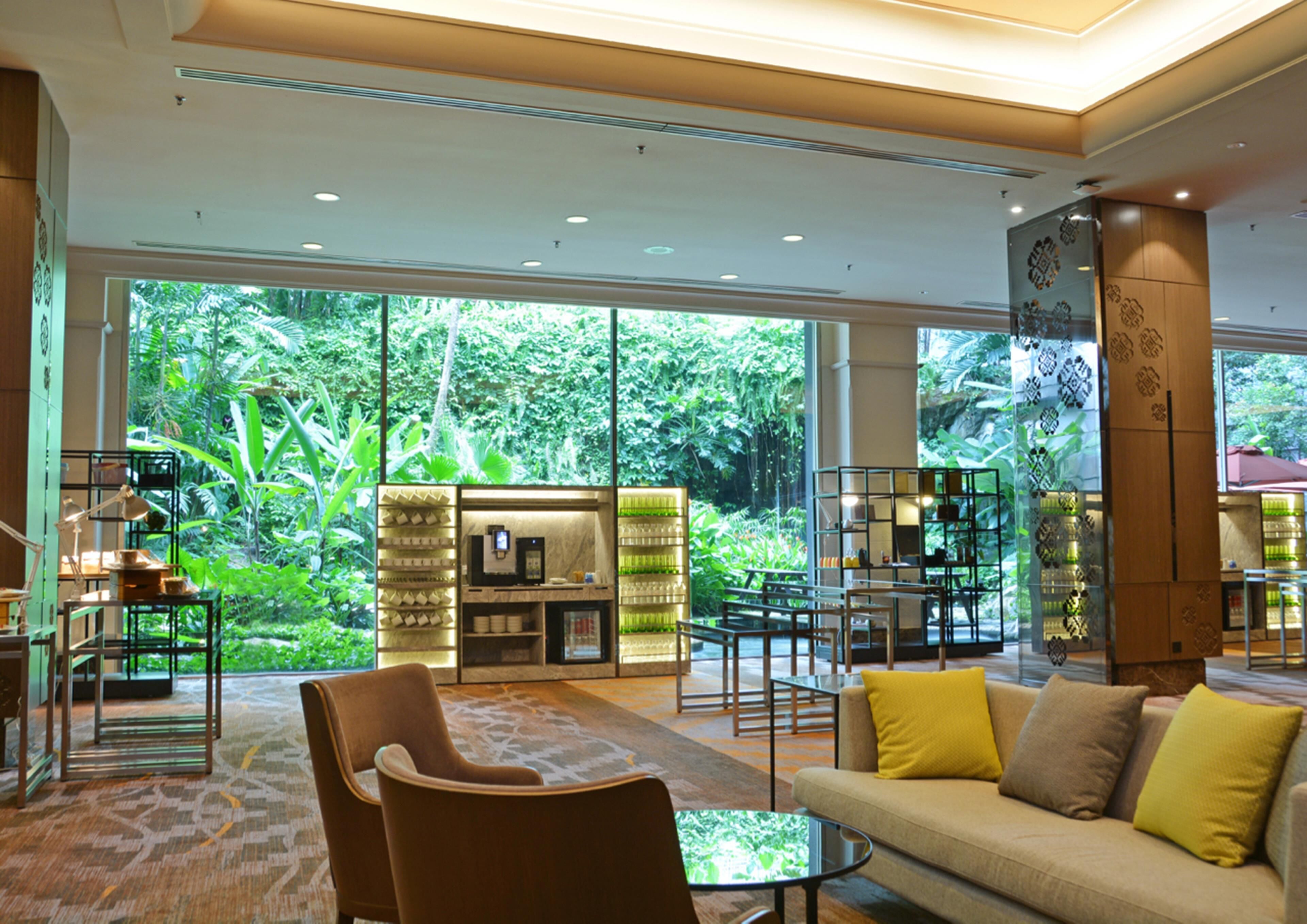 A spacious living area with large windows, a coffee station, and a seating arrangement.