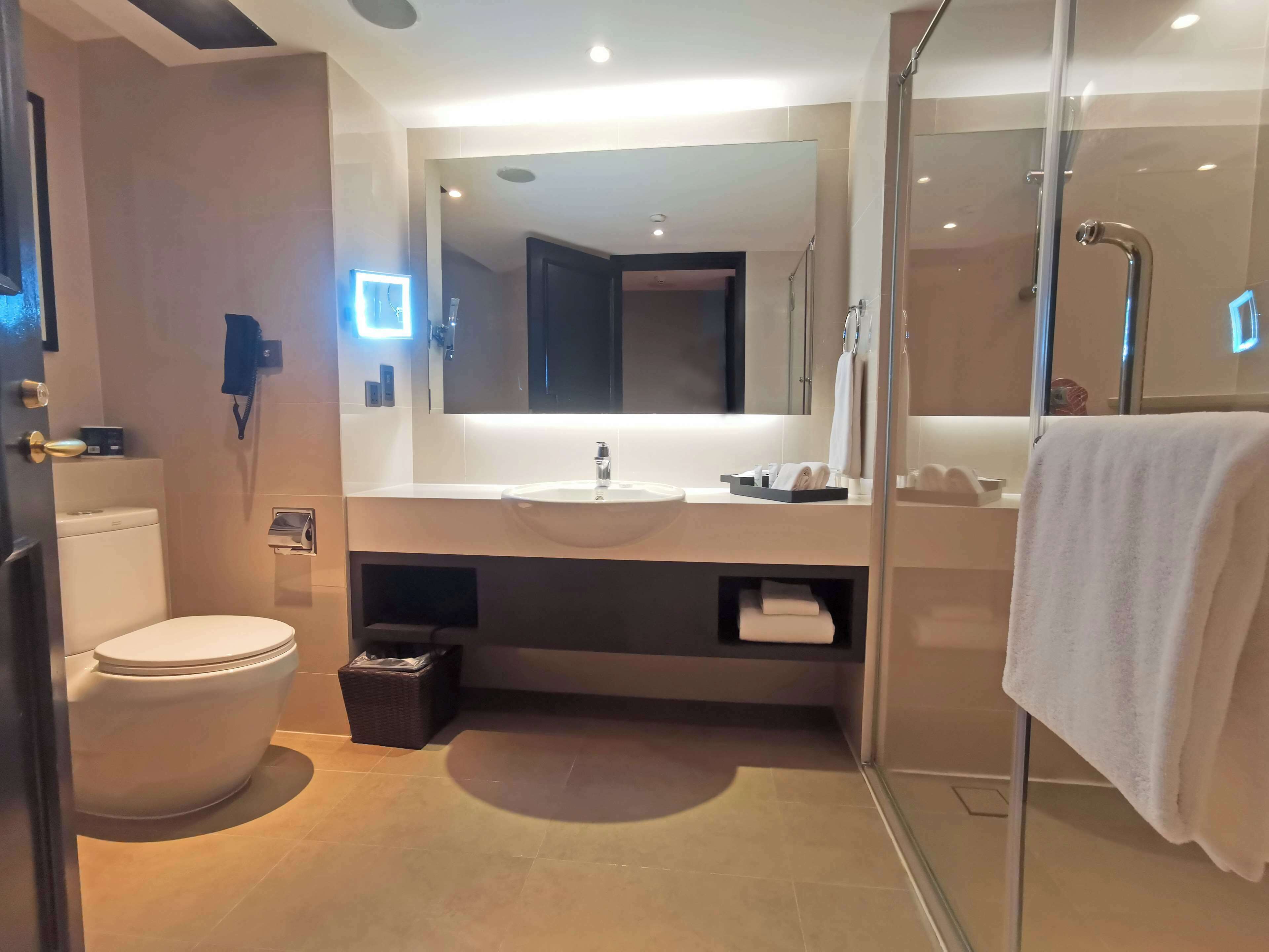 Un baño moderno con inodoro, lavabo y cabina de ducha de vidrio.