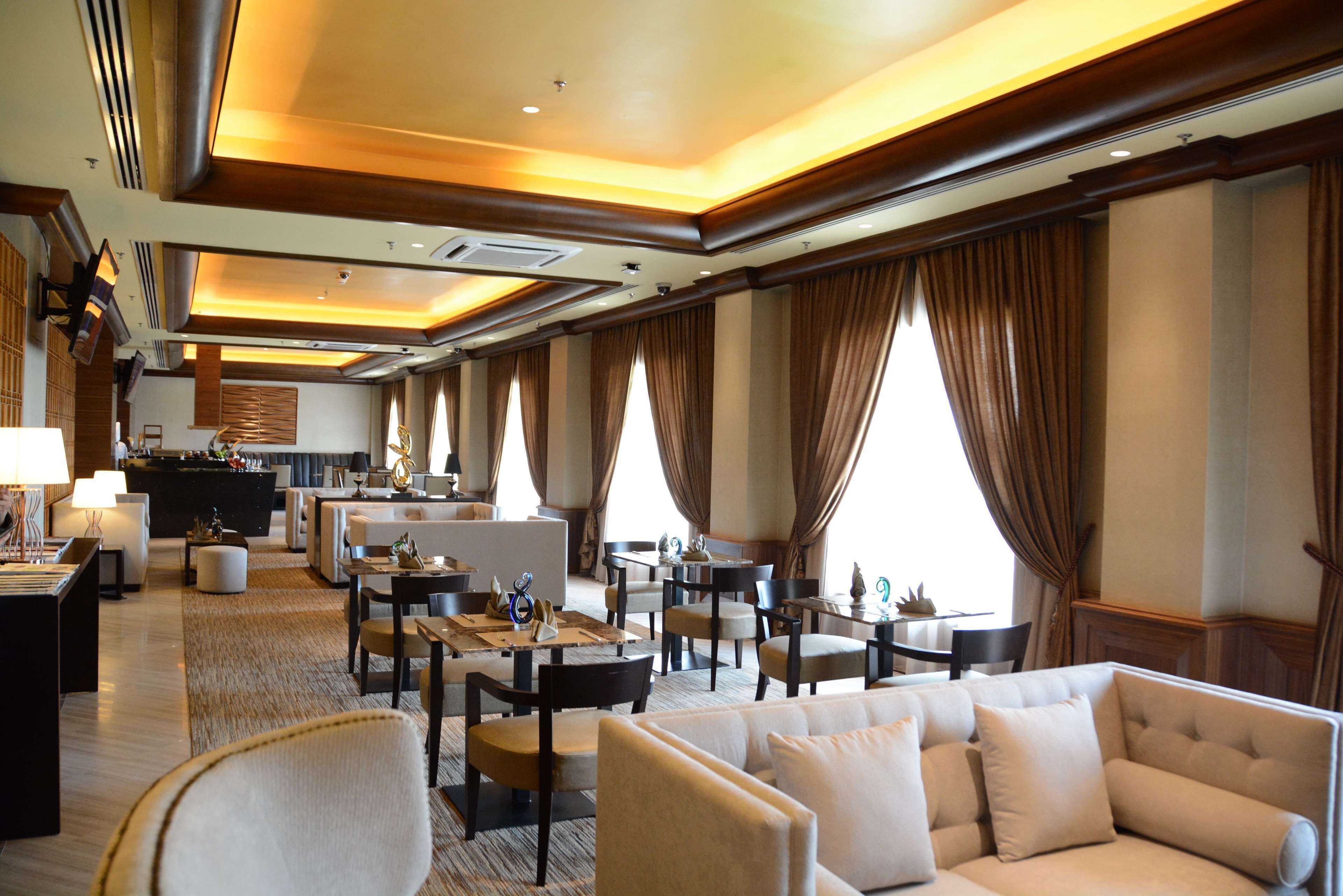 A hotel lobby with a seating area, a bar, and a reception desk.