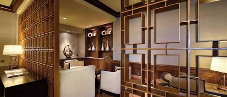 A hotel lobby with a reception desk, seating area, and decorative wall panels.