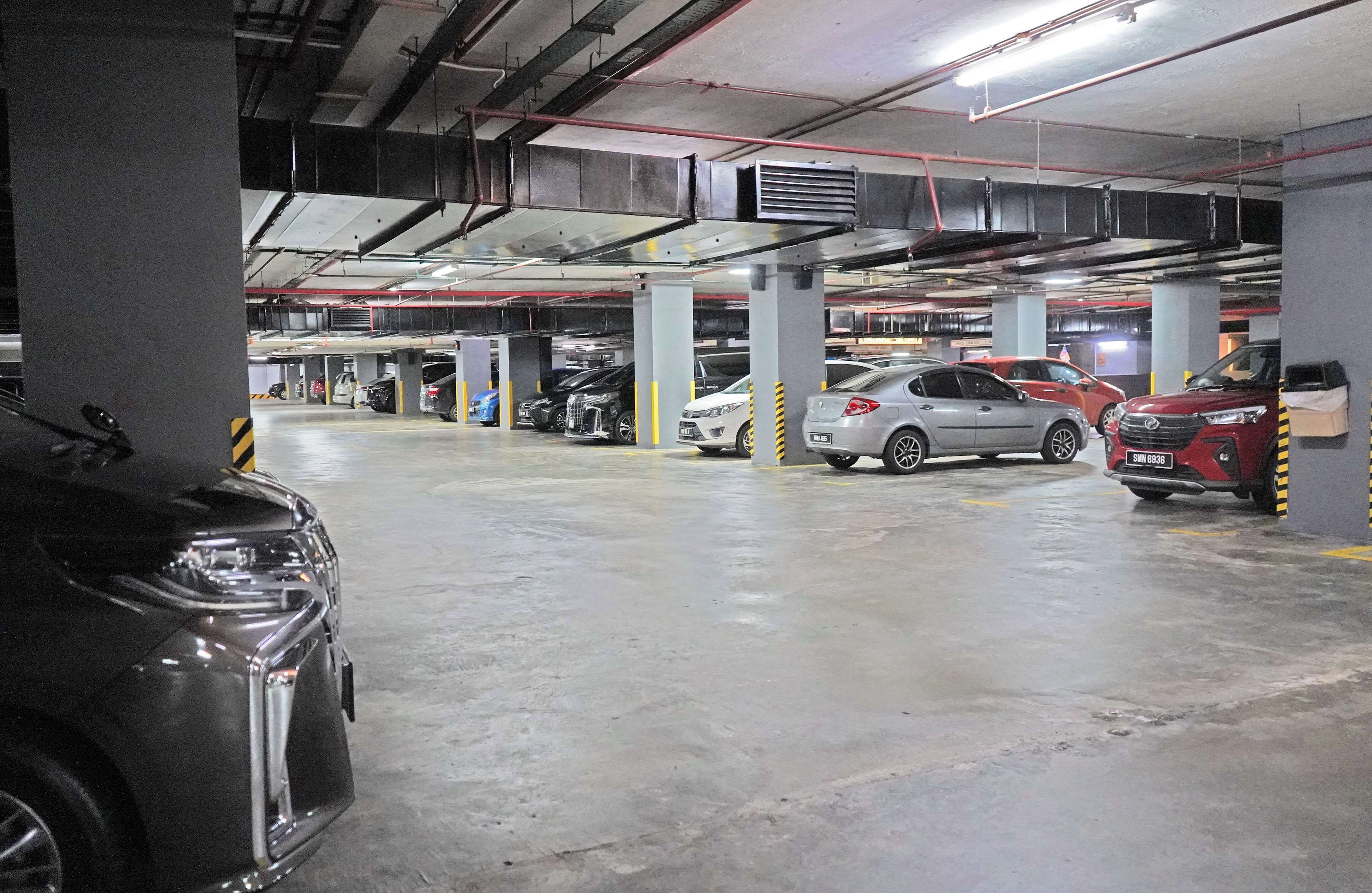 Un parking à plusieurs niveaux où sont garées plusieurs voitures.