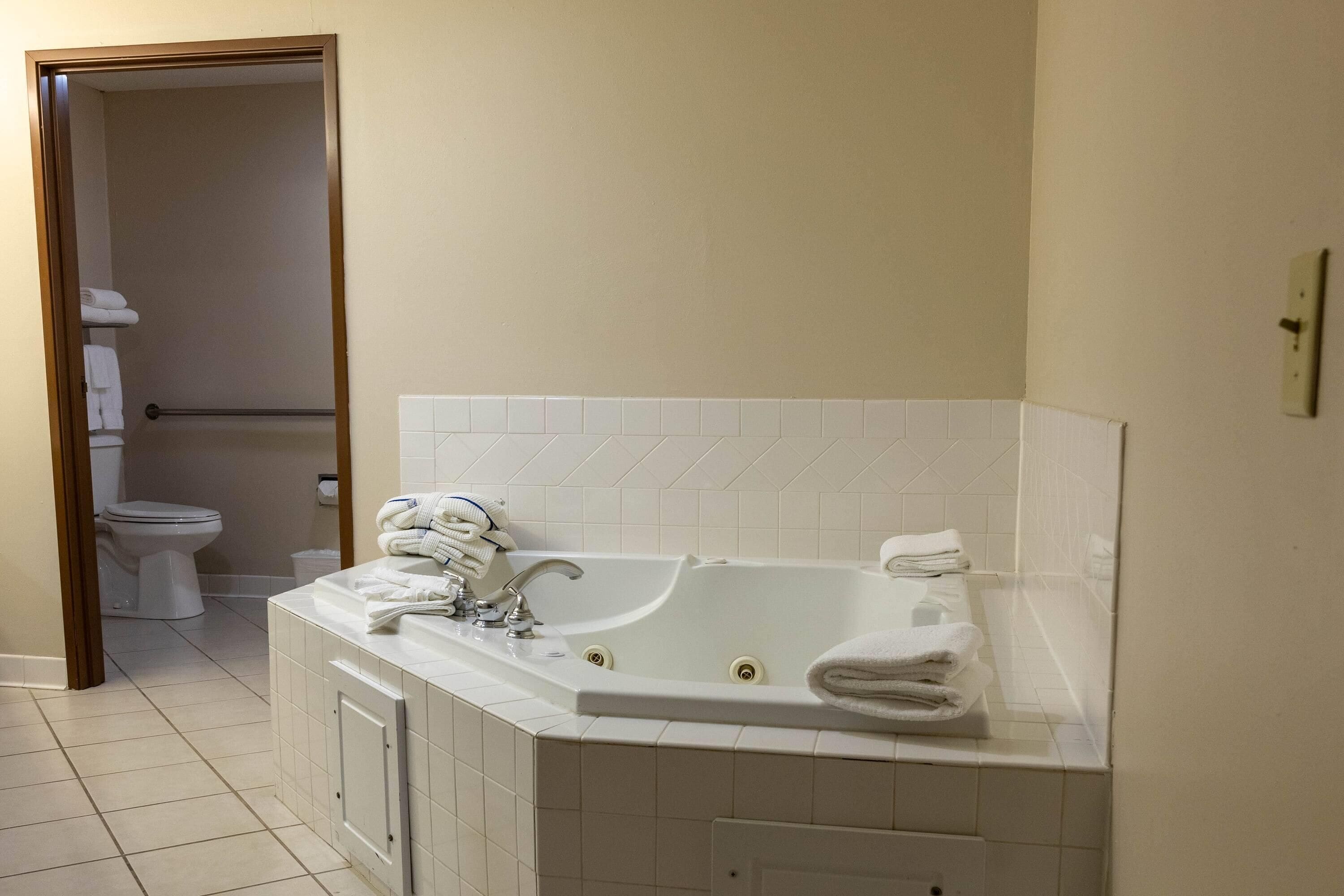 A bathroom with a bathtub, toilet, and a towel rack.