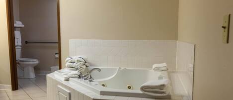 A bathroom with a bathtub, toilet, and a towel rack.