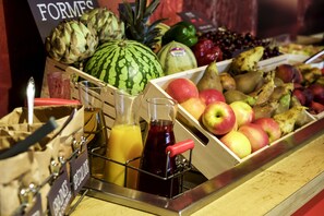 A fruit display with various types of fruits and a juice dispenser. - ibis Barcelona Cornella (Cornella de Llobregat)