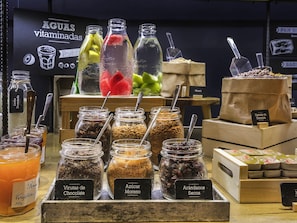 A display of various food items including jars of chocolate, sugar, and dried fruits, with a sign indicating 'Aguas vitaminadas' in the background. - ibis Barcelona Cornella (Cornella de Llobregat)