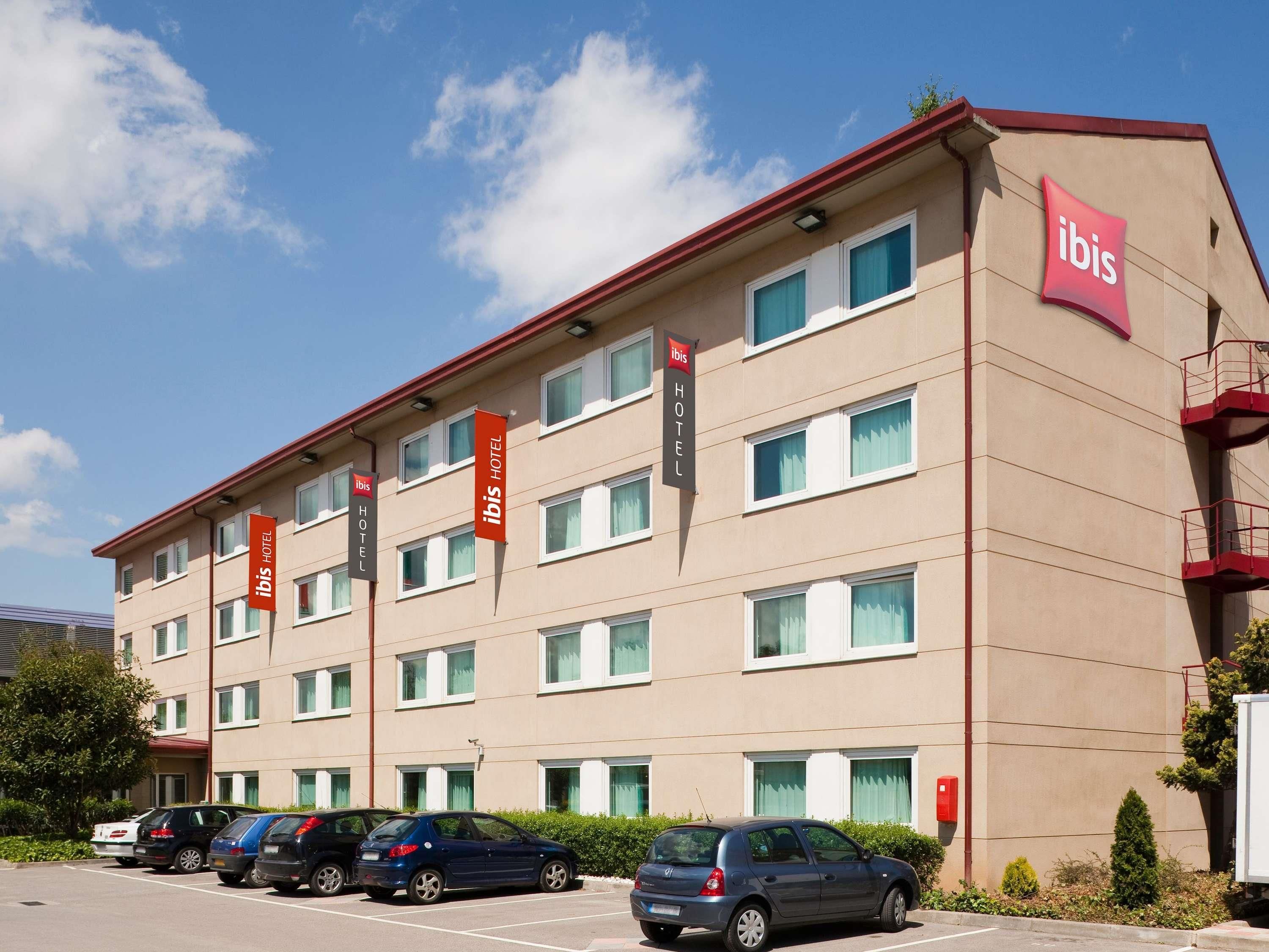 Un hôtel à plusieurs étages, doté d’un design moderne, avec une série de fenêtres et de balcons aux étages supérieurs.