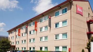 Un hôtel à plusieurs étages, doté d’un design moderne, avec une série de fenêtres et de balcons aux étages supérieurs.