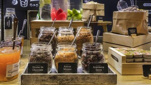 A display of various food items including jars of chocolate, sugar, and dried fruits, with a sign indicating 'Aguas vitaminadas' in the background. - ibis Barcelona Cornella (Cornella de Llobregat)