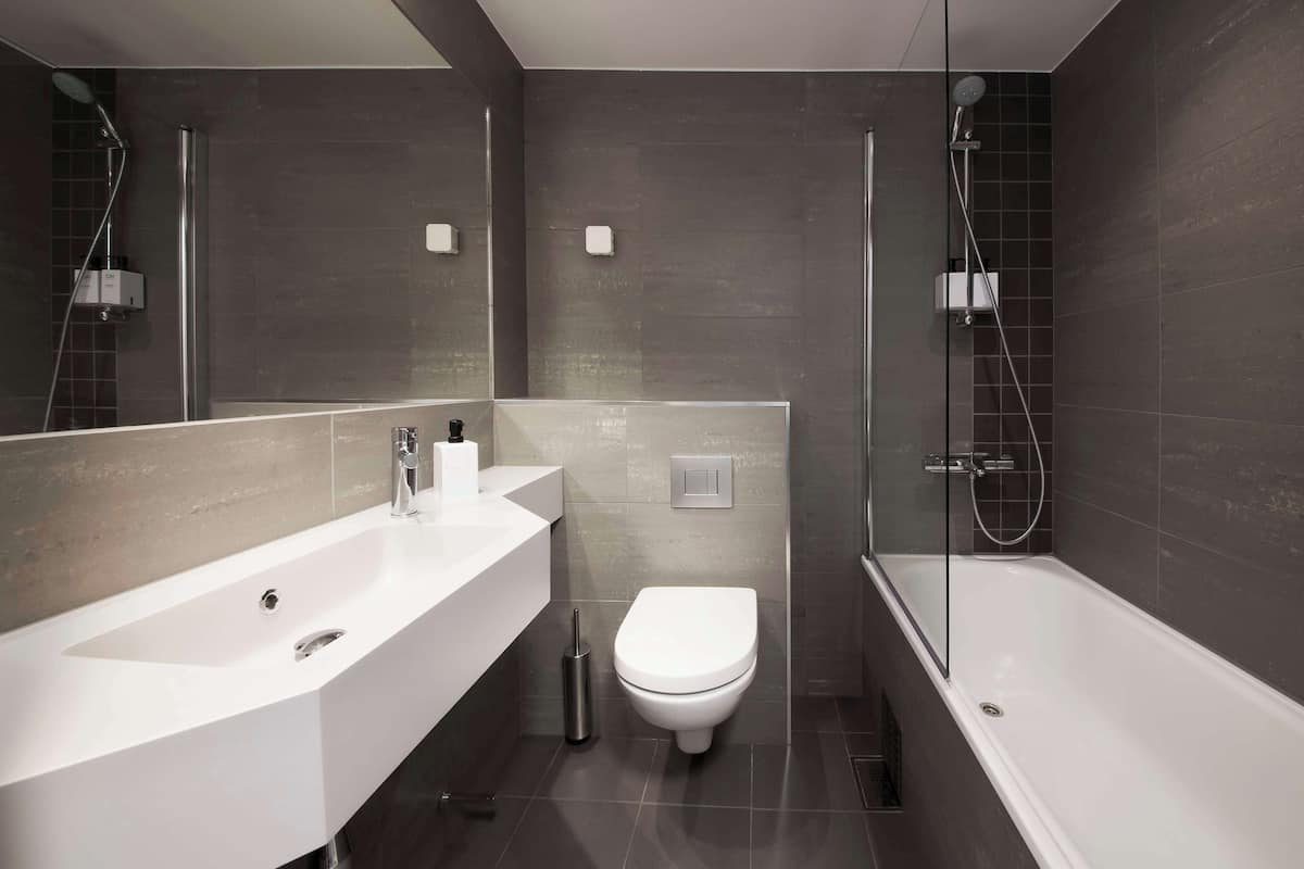 A modern bathroom with a large white bathtub, a separate shower area, and a white toilet.