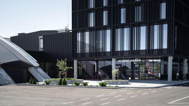 A modern building with a glass facade and a sign reading "SCANDIC HAMAR".