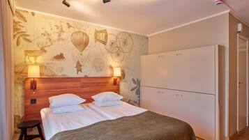 Une chambre d’hôtel comprenant un lit, une armoire, une table de chevet et un mur décoré d’une carte.