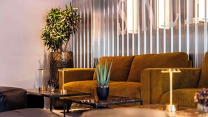 A modern living room with a sofa, coffee table, and a potted plant.
