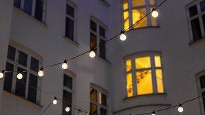A multi-story building with multiple windows, some illuminated from the inside.