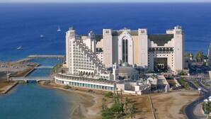 Un gran resort con varias construcciones, una playa y un puerto deportivo.