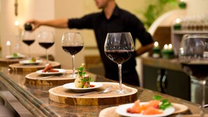 Una barra de restaurante con copas de vino y platos de comida.