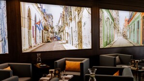 A restaurant with a view of a narrow street through large windows. There are multiple seating areas with tables and chairs. - Sombea Donaueschingen (Donaueschingen)