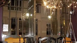 A room with a large window, a chandelier, and several chairs. - WHO - Windsor Hotel Opera (Paris)