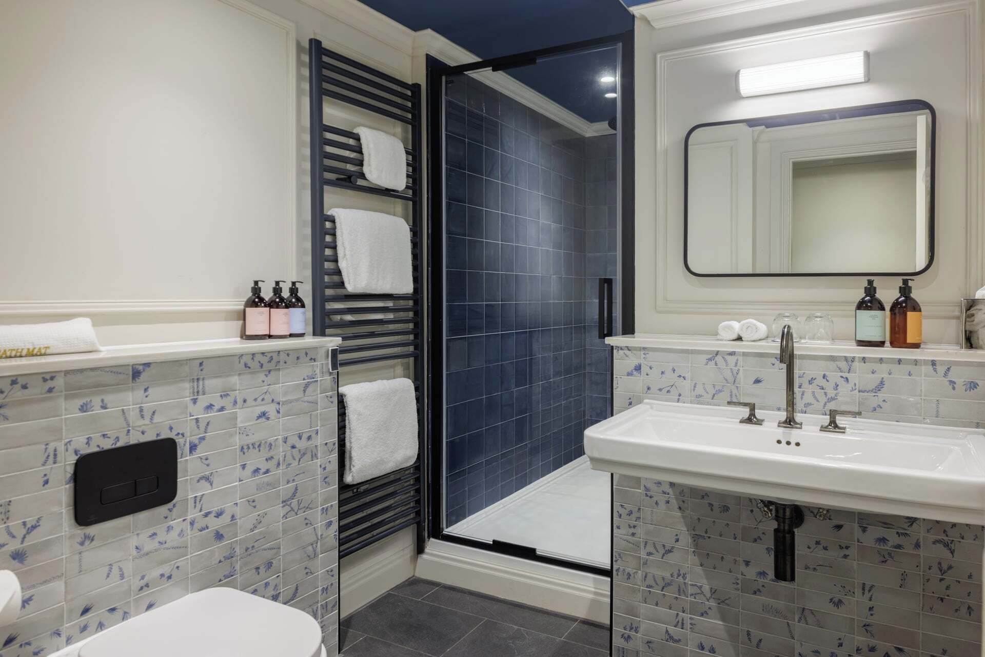 A modern bathroom with a shower, toilet, and sink.
