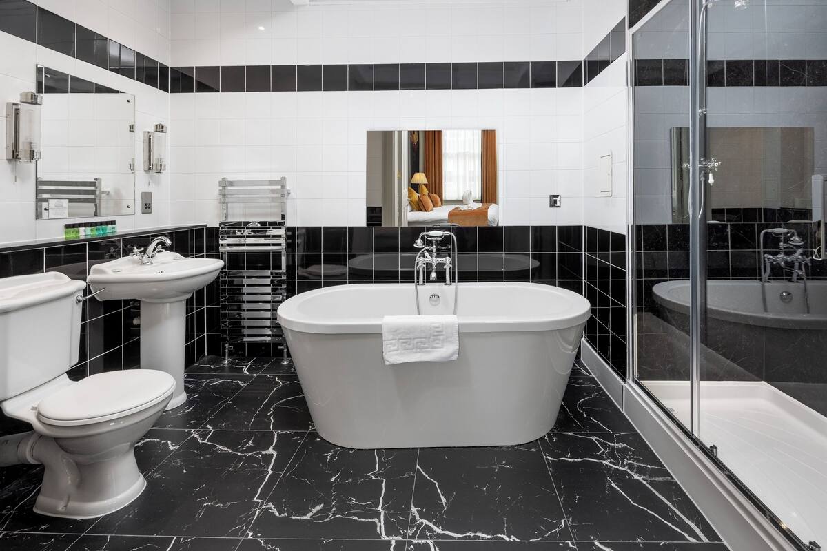 A modern bathroom with a freestanding bathtub, a toilet, and a sink.