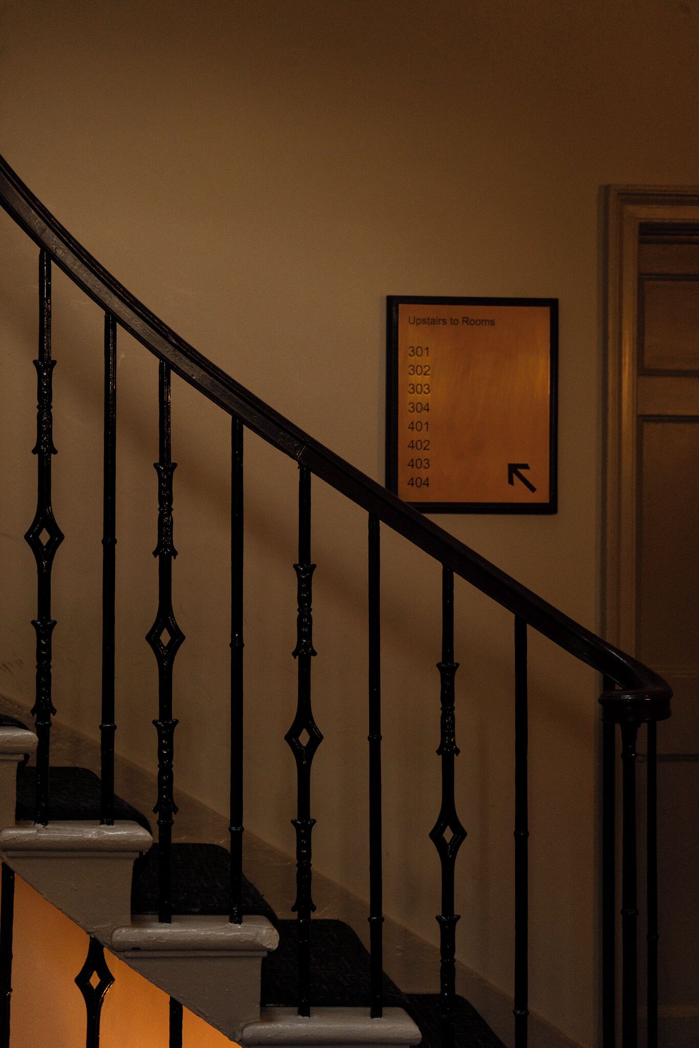 A staircase with a sign indicating room numbers 301 to 404.