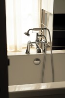 A bathroom with a bathtub, a shower, and a faucet.