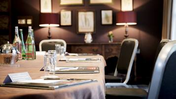 A conference room with a long table, chairs, and framed pictures on the wall.
