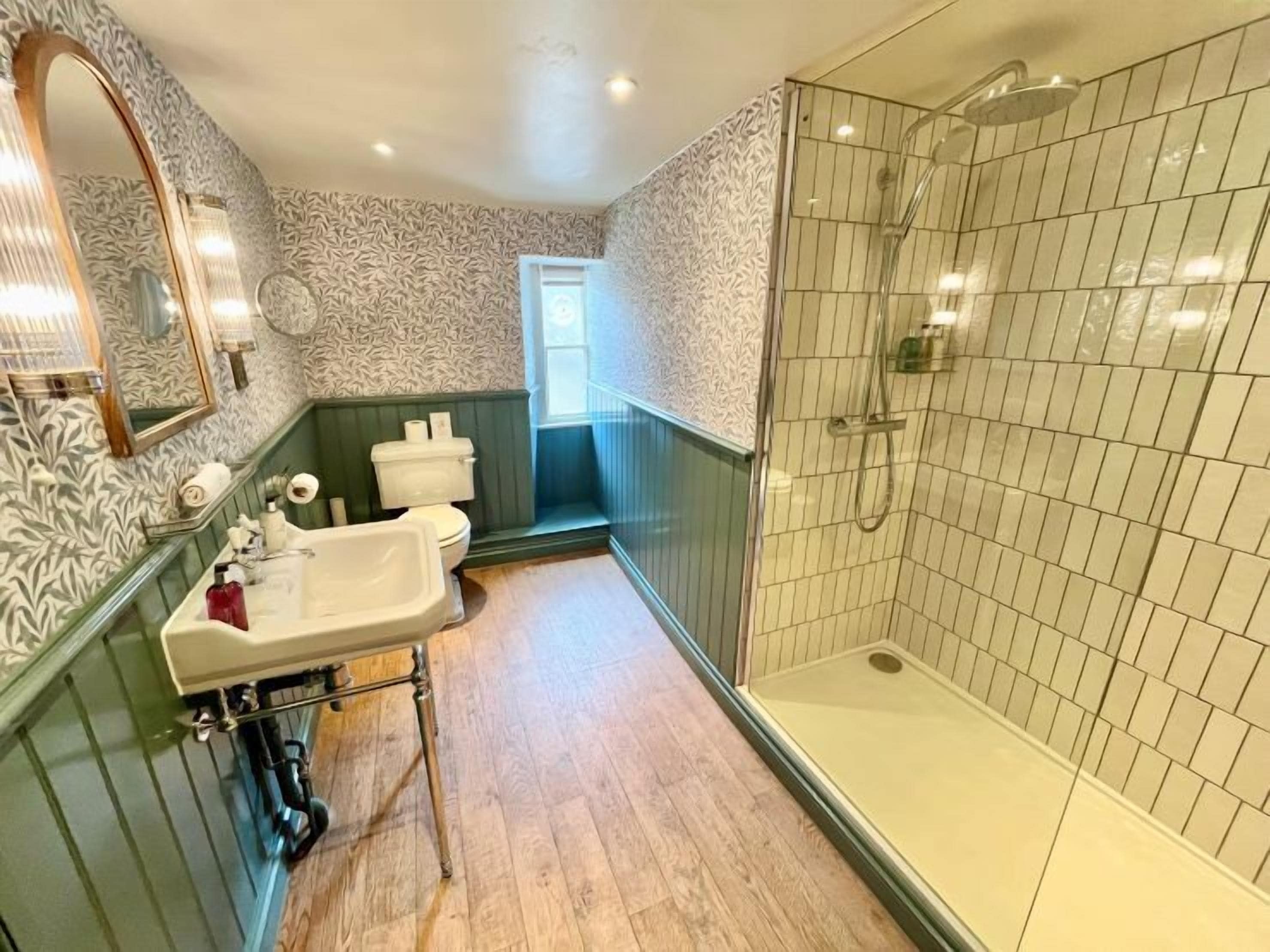 A bathroom with a shower, toilet, and sink.