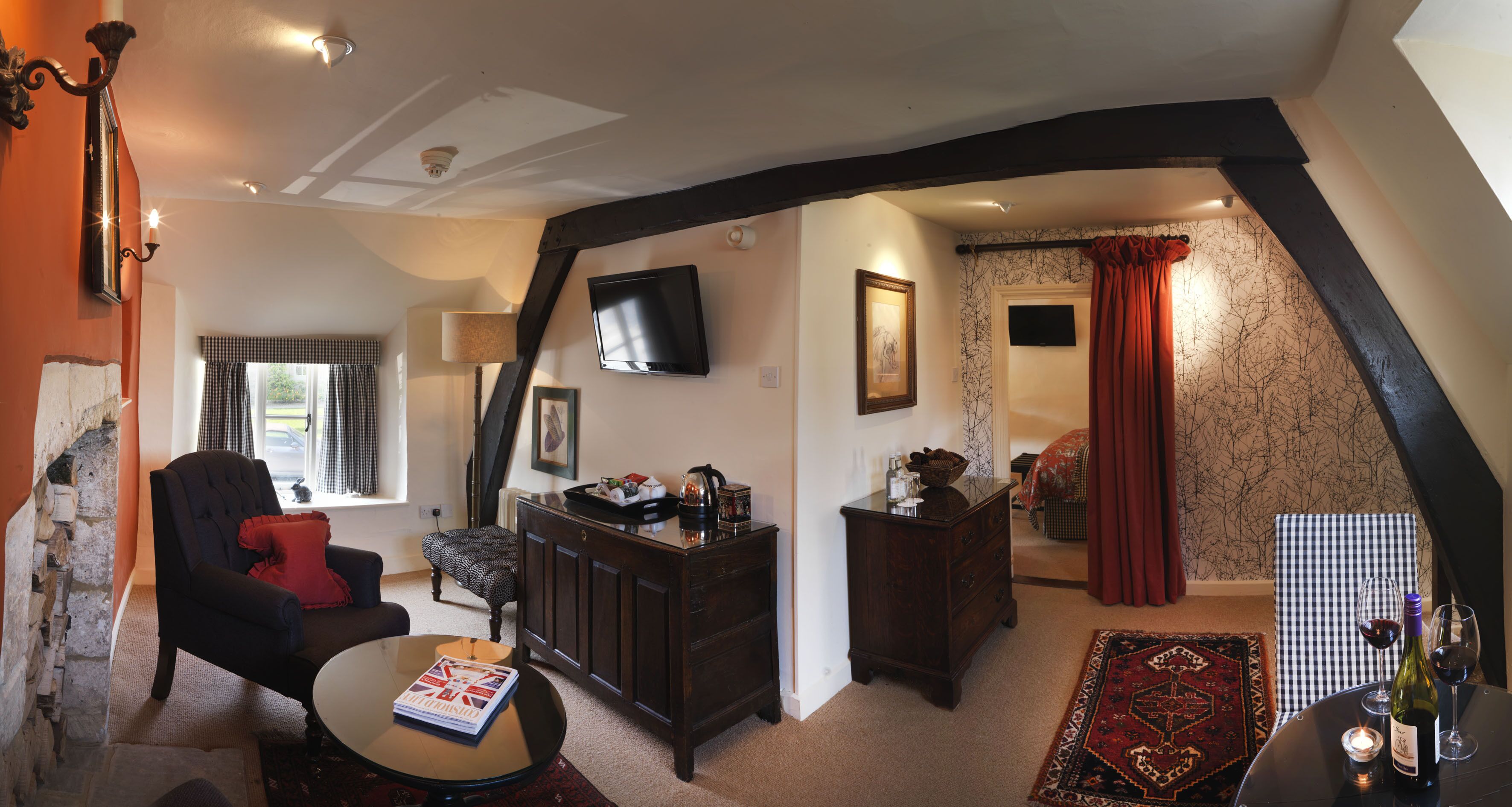 A cozy living room with a fireplace, a television, and a dining area with a table and chairs.