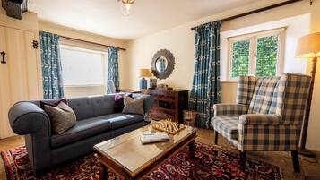 Een woonkamer met een bank, fauteuil, salontafel en een schaakbord.