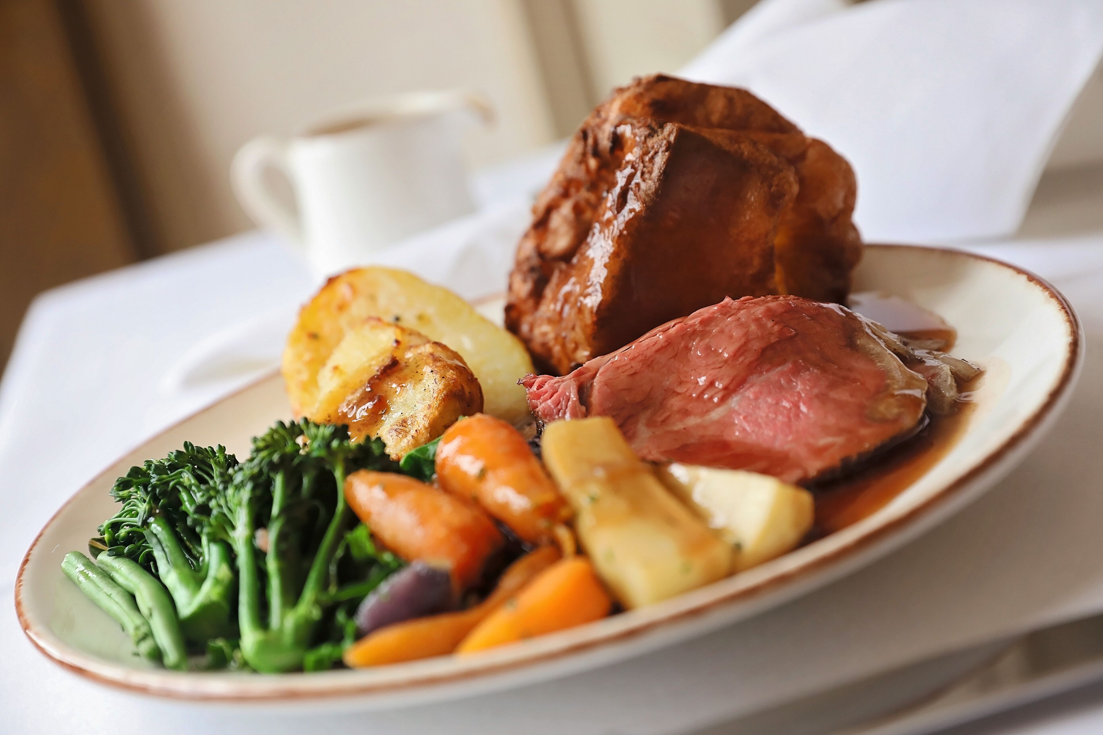 A plate of food including roast beef, potatoes, carrots, and broccoli.