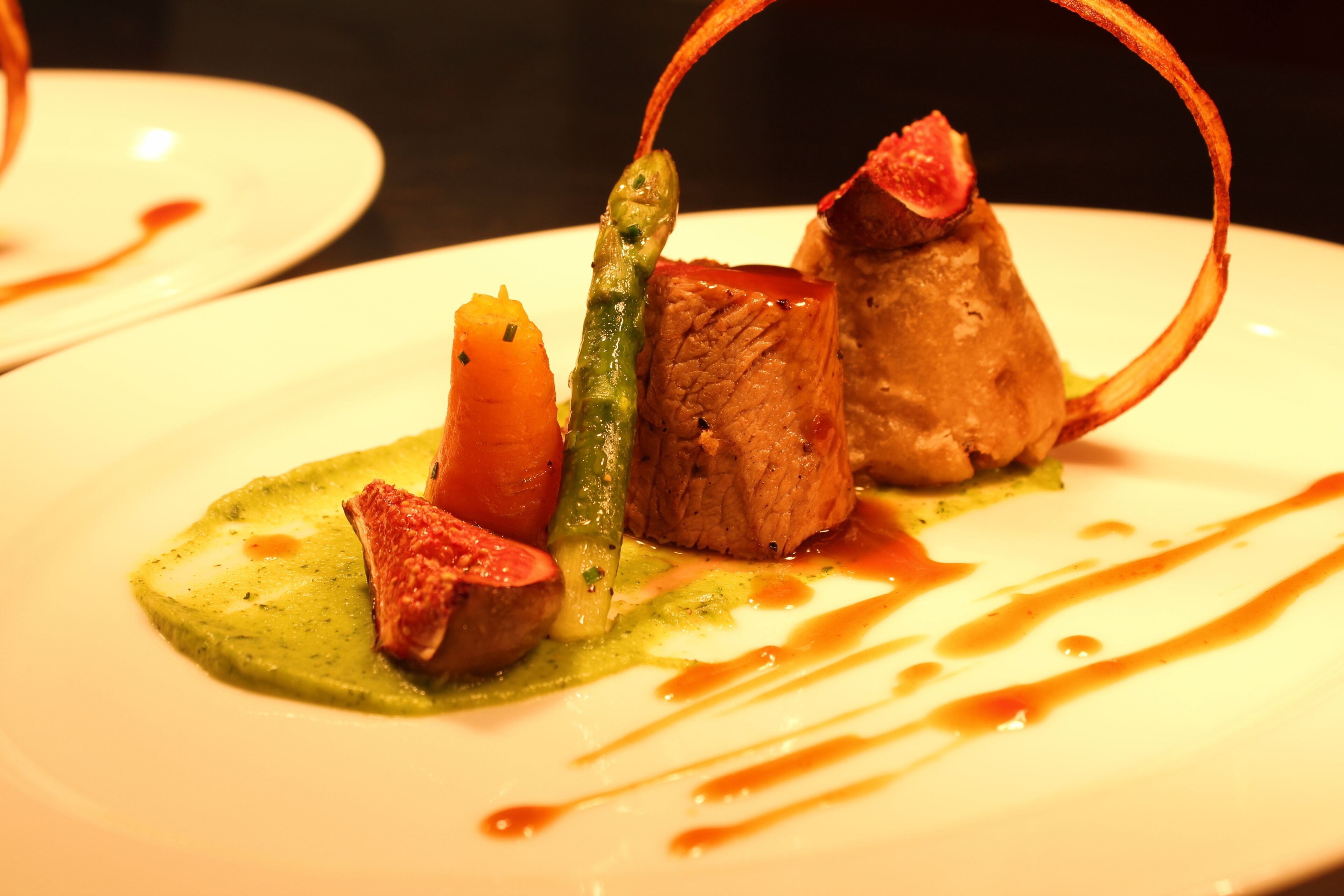 Un plato de comida con diferentes ingredientes, incluyendo carne, verduras y salsa.
