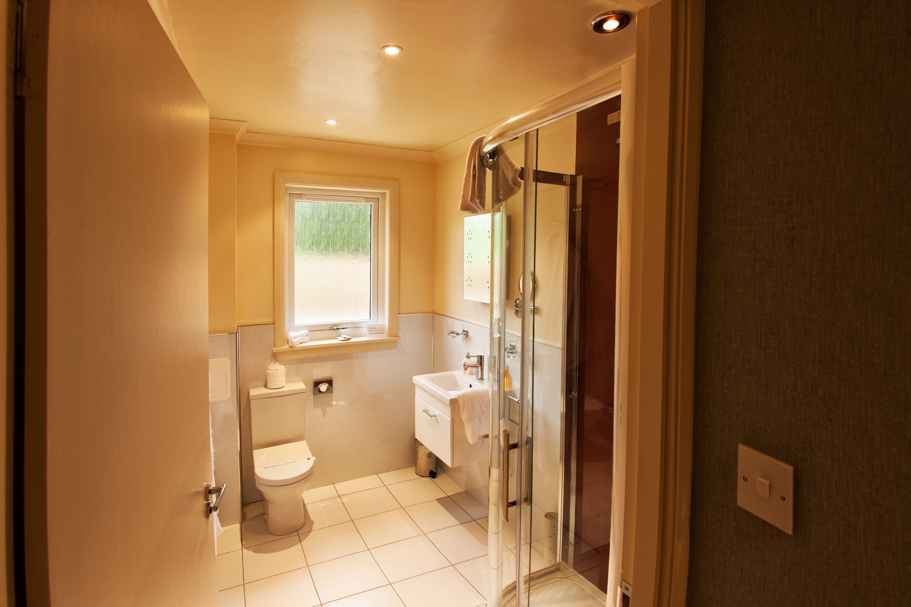 Een badkamer met toilet, wastafel en douche.