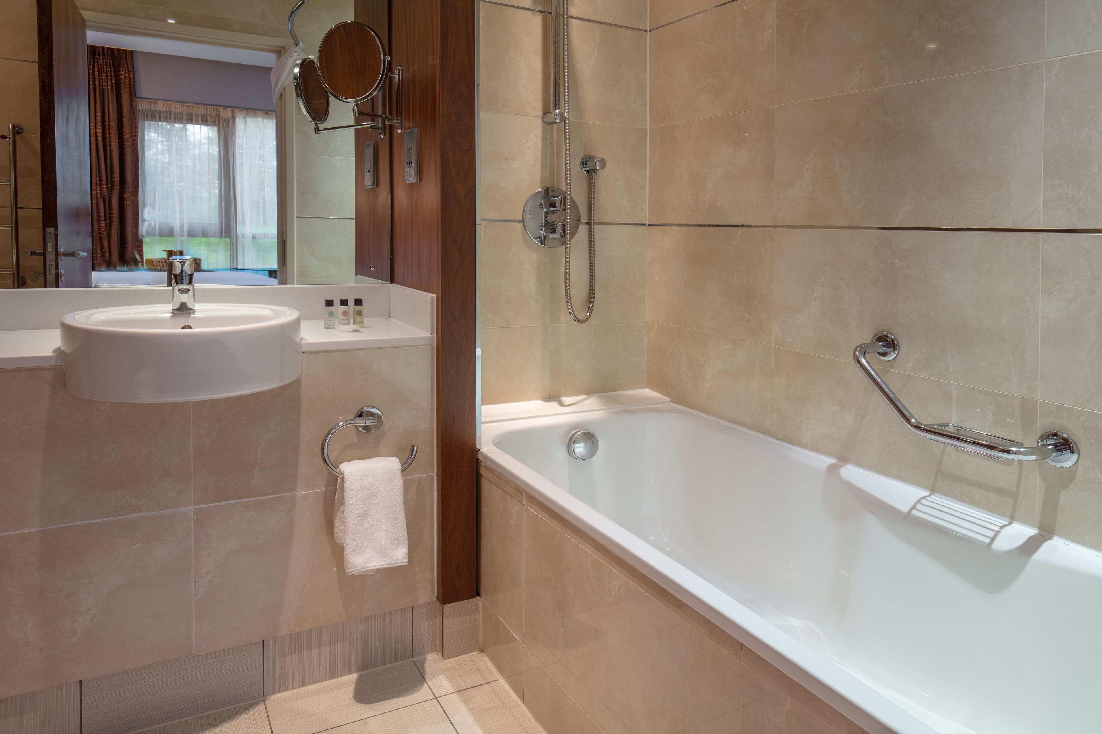 A modern bathroom with a bathtub, a sink, and a shower.