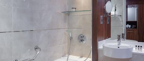 A modern bathroom with a bathtub, shower, and sink.