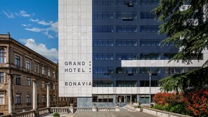 A modern hotel building with a sign reading "Grand Hotel Bonavita."